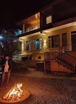 Un bâtiment moderne à deux étages, avec un foyer au premier plan, un escalier et un balcon.