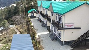A hotel with a green roof, multiple balconies, and a sign reading 'KURFI PARADISE'. - Kufri Paradise Villa By Mountain Bee (Theog)