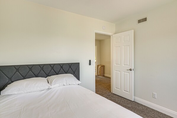 A bedroom with a bed, a door, and a hallway. - Hot Tub, Pool & SoCal Sunsets: San Diego Area Home (Spring Valley)