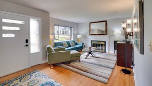 A living room with a sofa, armchairs, a coffee table, a fireplace, and a large mirror. - Deck & Patio! Walkable Downtown Cary Home (Cary)