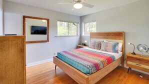 A bedroom with a wooden bed, a ceiling fan, a bedside table, a nightstand, and a mirror. - Deck & Patio! Walkable Downtown Cary Home (Cary)