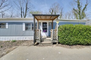 A mobile home with a porch, a door, and a small garden area. - 6 Mi to Fort Knox! Rural Family Home, Pets Welcome (Radcliff)
