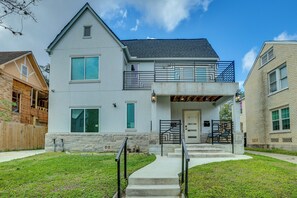 A two-story house with a balcony, a front porch, and a visible garage. - 3 Mi to Dtwn Houston: Dual-Unit Home w/ Yard! (Houston)