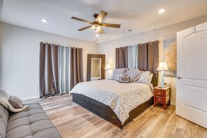 A bedroom with a bed, a ceiling fan, a nightstand, a door, and a view of the hallway. - 3 Mi to Dtwn Houston: Dual-Unit Home w/ Yard! (Houston)