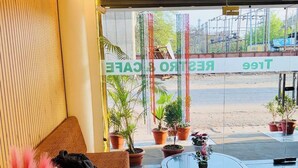A hotel lobby with a sofa, a table, and potted plants. - The Mint Tree Hotels & Resorts (Bhopal)