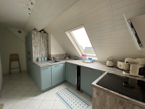 A kitchen with a skylight, a sink, cabinets, and appliances. - Apartment Sea view Cabourg (Cabourg)