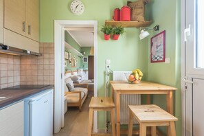 Una cocina con una mesa de madera, un banco y un frutero.