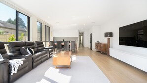 A modern living room with a sofa, coffee table, and a large TV.