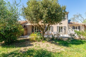 A house with a garden, outdoor seating, and a tiled roof.