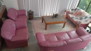 A room with a pink sofa, a wooden coffee table, and a patterned sofa. - Private farmhouse in the bush with AC, just outside Windhoek on a game farm. (Windhoek)