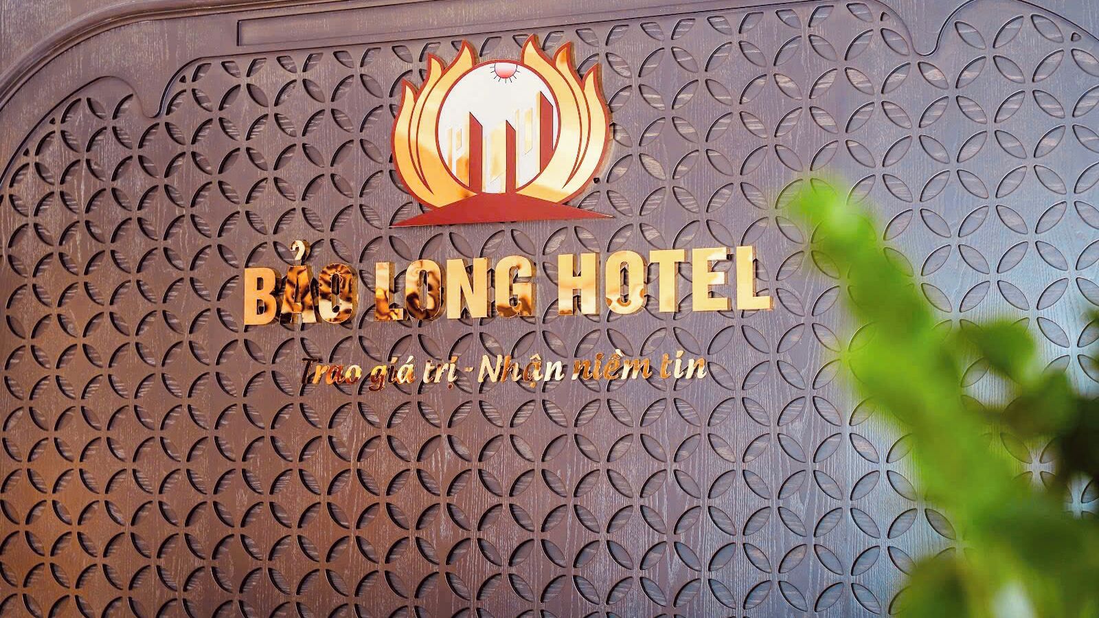 A hotel sign with a logo and the name 'BHLONG HOTEL' in gold letters.