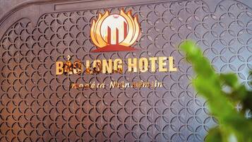 A hotel sign with a logo and the name 'BHLONG HOTEL' in gold letters.