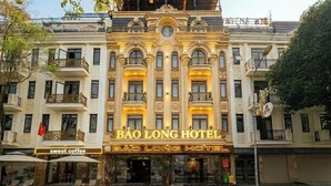 Un hotel con fachada clásica, balcones y un cartel que dice 'BÃO LONG HOTEL'.