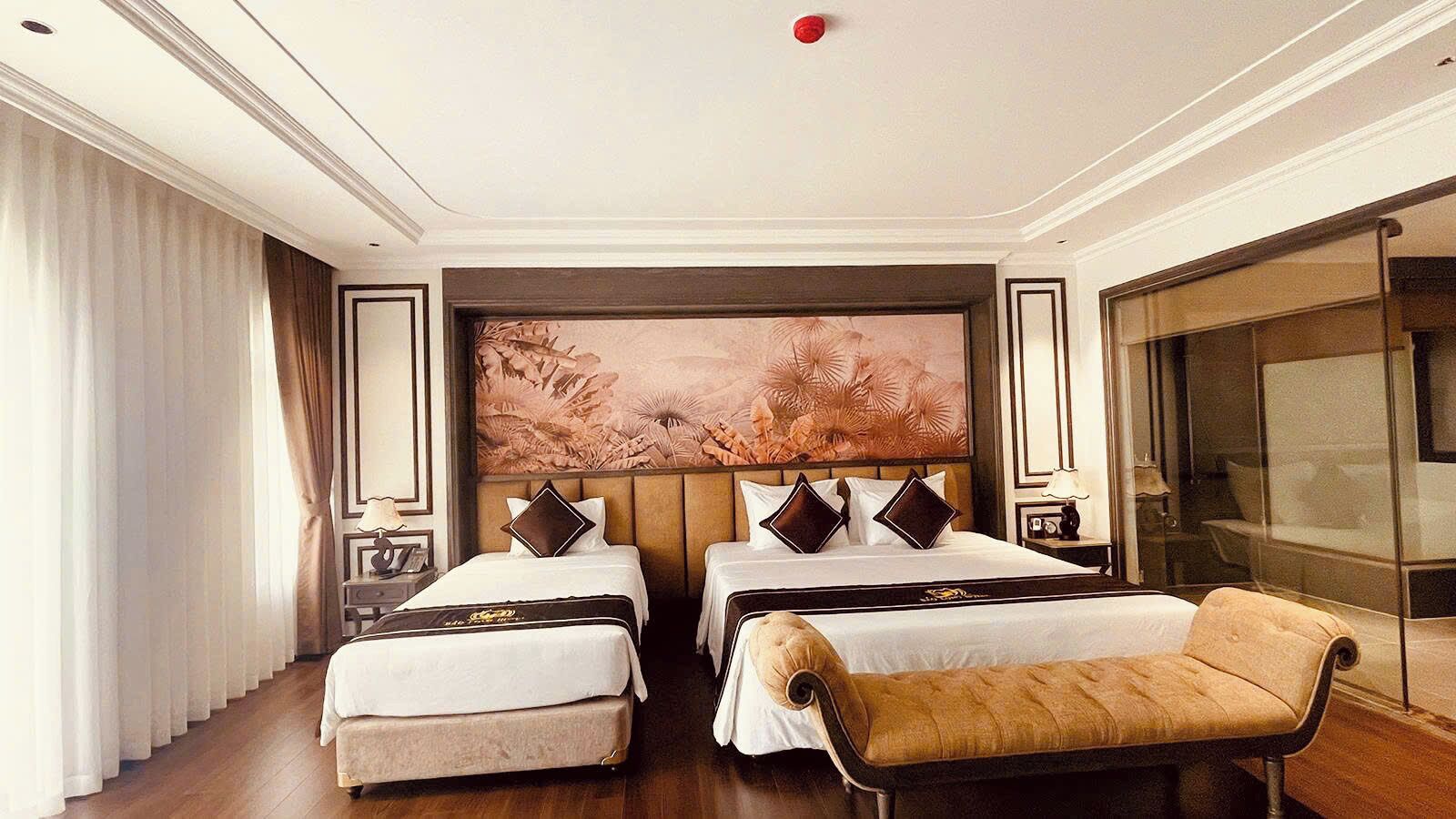 A hotel room with two beds, a sofa, a large window, and a painting on the wall.