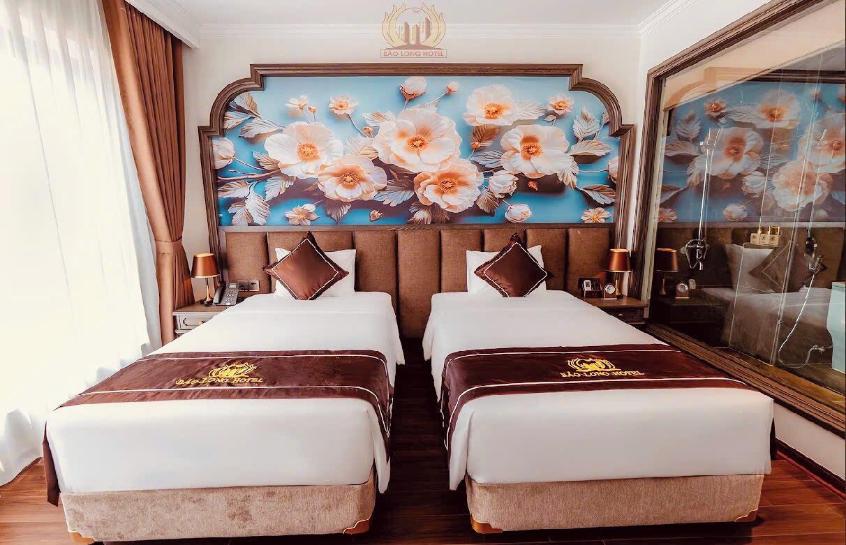 A hotel room with two beds, a large floral mural on the wall, and a large mirror.