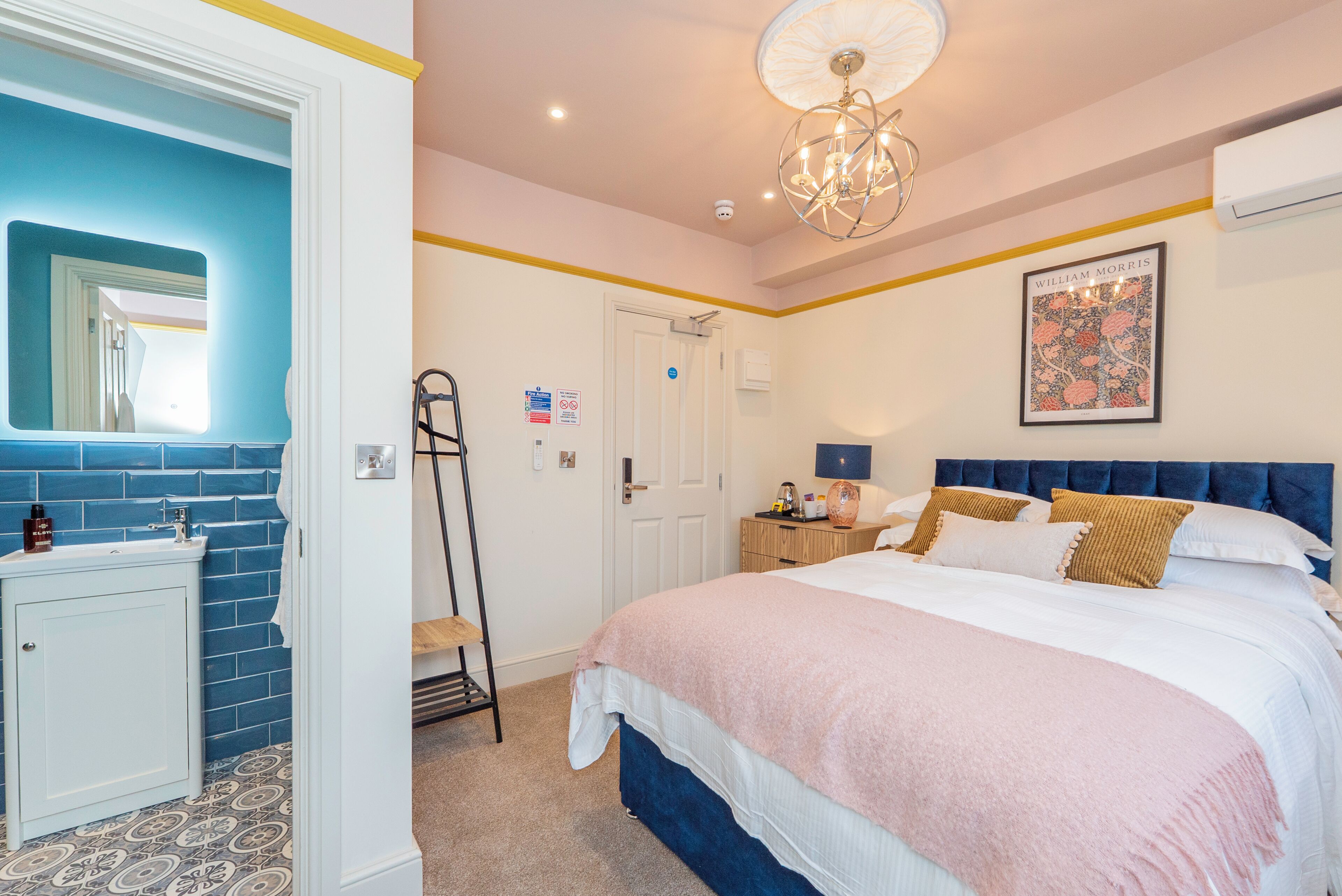 A bedroom with a bed, bedside table, and a mirror.