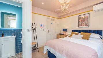A bedroom with a bed, bedside table, and a mirror.