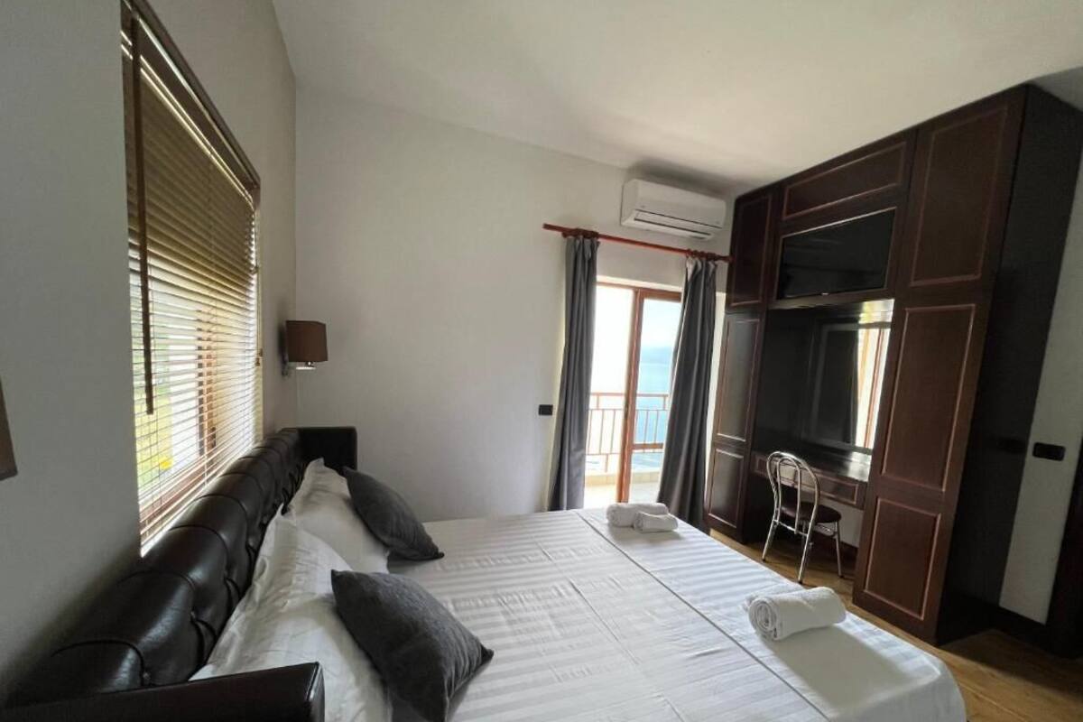 Ein Schlafzimmer mit einem großen Bett, einem Schreibtisch und einem Fernseher.