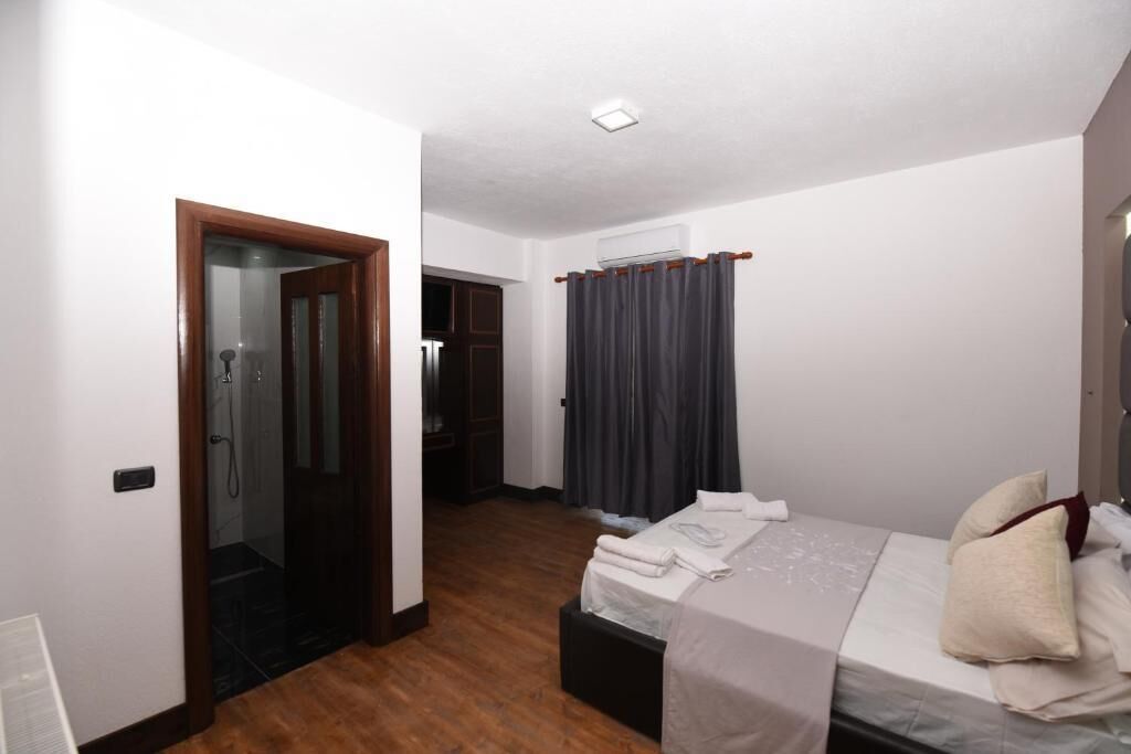 Hotellihuone, jossa on sänky, kylpyhuone ja suihkutila.