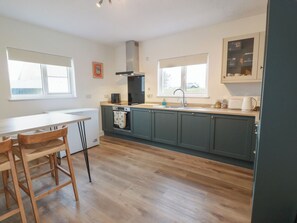 A kitchen with a central island, a built-in oven, and a sink.