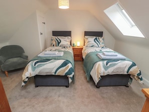 A bedroom with two beds, a nightstand, a chair, and a skylight. - South Kirklauchline Farm (Stranraer)