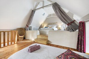 A bedroom with a bed, a chair, a window, and a staircase. - Gîte "Gite De La Rampotiere" with Private Terrace, Garden, and Wi-Fi (Quettreville-sur-Sienne)