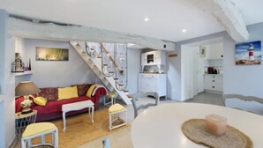 A cozy interior with a staircase, a dining area, and a kitchen. - Gîte "Gite De La Rampotiere" with Private Terrace, Garden, and Wi-Fi (Quettreville-sur-Sienne)