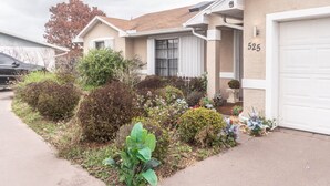Ein Wohnhaus mit Garage, Hausnummer 525, und einem gepflegten Garten mit verschiedenen Pflanzen und Blumen.