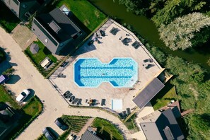 An aerial view of a residential area with a swimming pool, multiple cars, and surrounding greenery. - Beautiful chalet with private parking space and quietly situated on the edge of our park. (Sint Maarten)