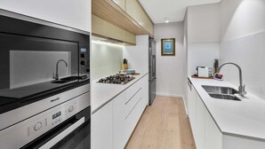 Eine moderne Küche mit eingebautem Herd, Spüle und Holzboden.