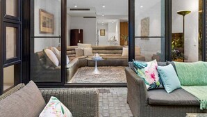 Ein modernes Wohnzimmer mit einer Couch, einem Couchtisch und einem Korbstuhl.