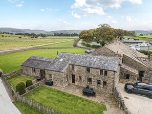 A stone building with a patio, a car, and a view of the countryside. - Orcaber Farm Retreat (Lancaster)