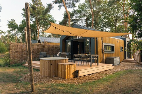 Enjoy a romantic stay in the Forest Lodge with hot tub for 2 people. A comfortable holiday villa in the middle of nature with a terrace, luxury kitchen and rain shower.
