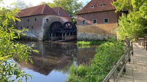 A historic building with large water wheels and a canal. - Luxury Forest Lodge with hot tub and sauna for 2 people. Enjoy peace, nature and comfort with private wellness, a terrace and a modern kitchen. (Lattrop-Breklenkamp)