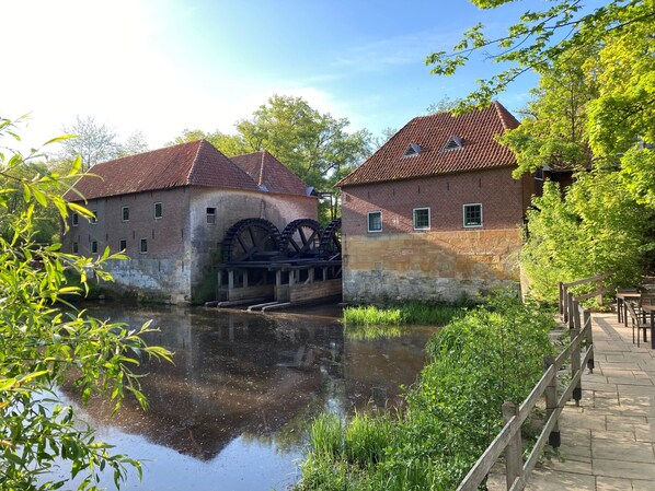 Un edificio histórico con grandes ruedas hidráulicas y un canal.