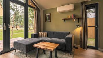 A modern living room with a sectional sofa, a wooden coffee table, and a large sliding glass door leading to an outdoor area.