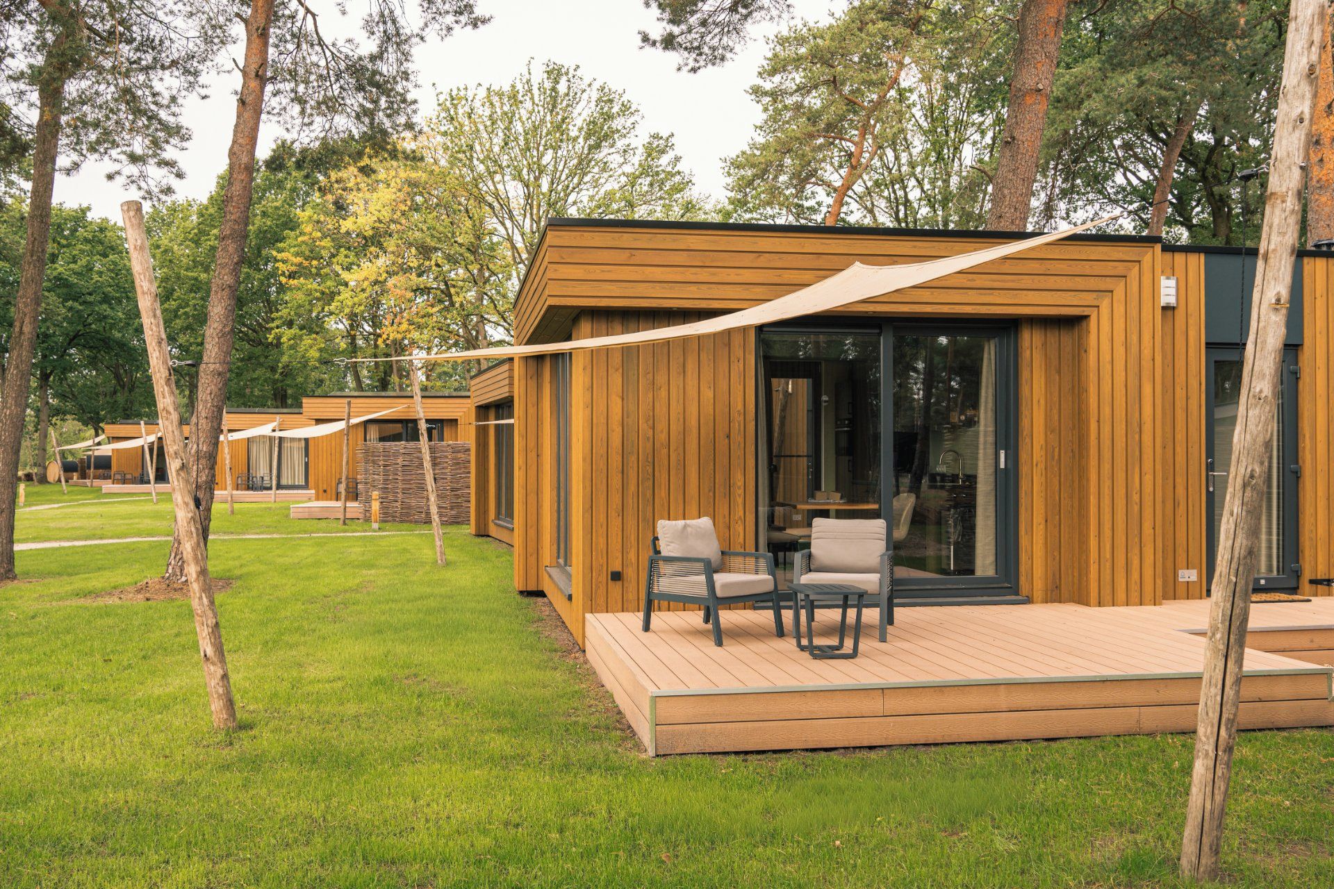 Eine Reihe von Holzhütten mit Terrasse und Sitzbereich im Freien.