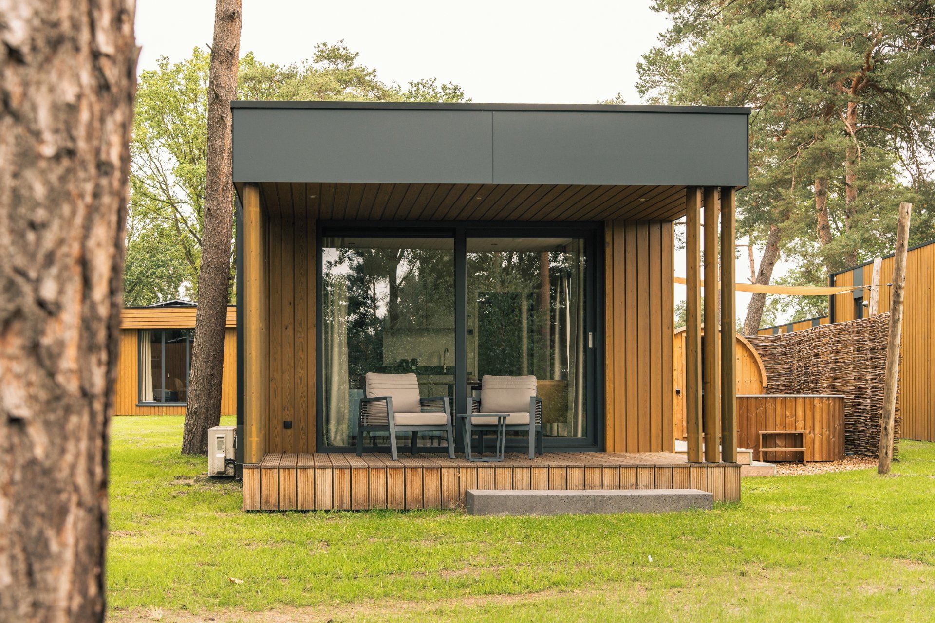 Een moderne, gelijkvloerse houten constructie met een overdekt terras.