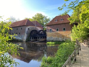Um edifício histórico com grandes rodas d'água e um canal.