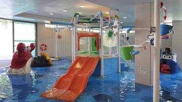 An indoor water play area with slides and water features.