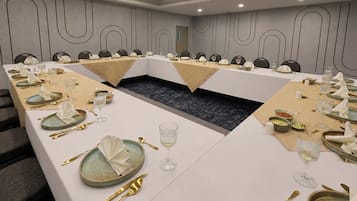 A conference room with a long table, chairs, and a central aisle.