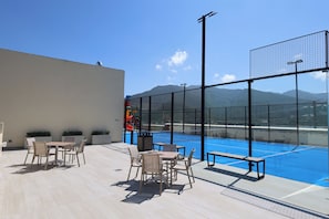 An outdoor seating area with tables and chairs, a pool, and a view of mountains. - Holiday Inn Resort Monterrey Santiago by IHG (Santiago)
