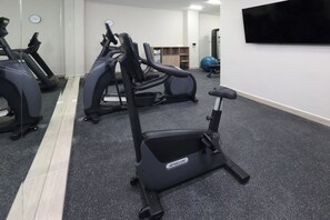 A gym with stationary bikes, a treadmill, and an elliptical machine. - Holiday Inn Resort Monterrey Santiago by IHG (Santiago)