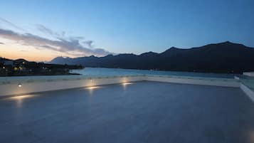 Une terrasse sur le toit offrant une vue sur les montagnes et un plan d’eau.