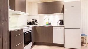 Una cocina moderna con armarios de madera, un refrigerador Bosch, una cafetera y un lavavajillas.