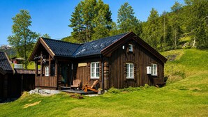 Una casetta di legno con veranda, due finestre e un camino.
