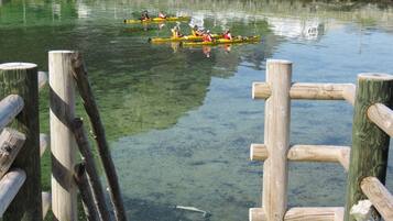 Un muelle de madera con kayaks en el agua.