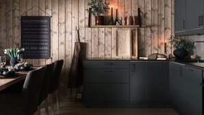 Una cucina con rivestimenti in legno, un menu alla lavagna e un arredamento rustico.