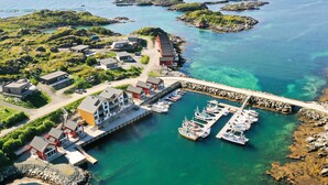 An aerial view of a coastal area with a marina, boats, and buildings.