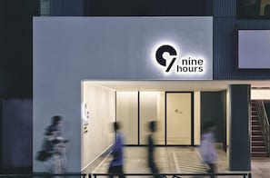 En bygning med et skilt, der viser ’nine hours’, og en glasklædt indgang.